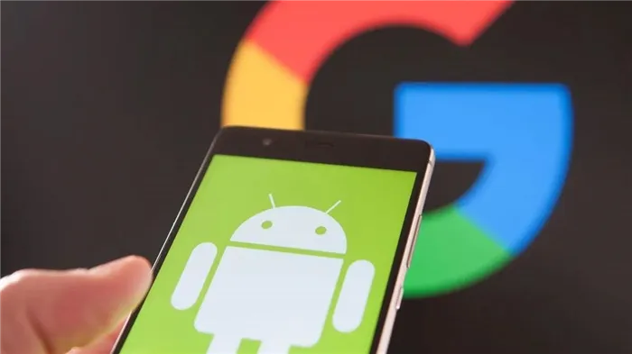 Android на рабочем столе смартфона в руке пользователя на фоне логотипа Google